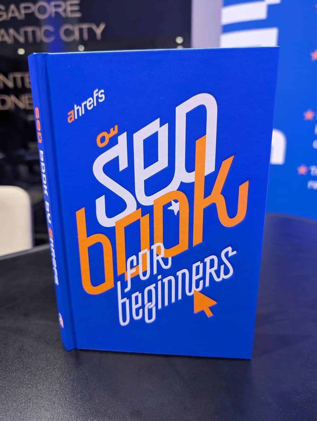 Blue “SEO for Beginners” book by Ahrefs displayed upright on a table