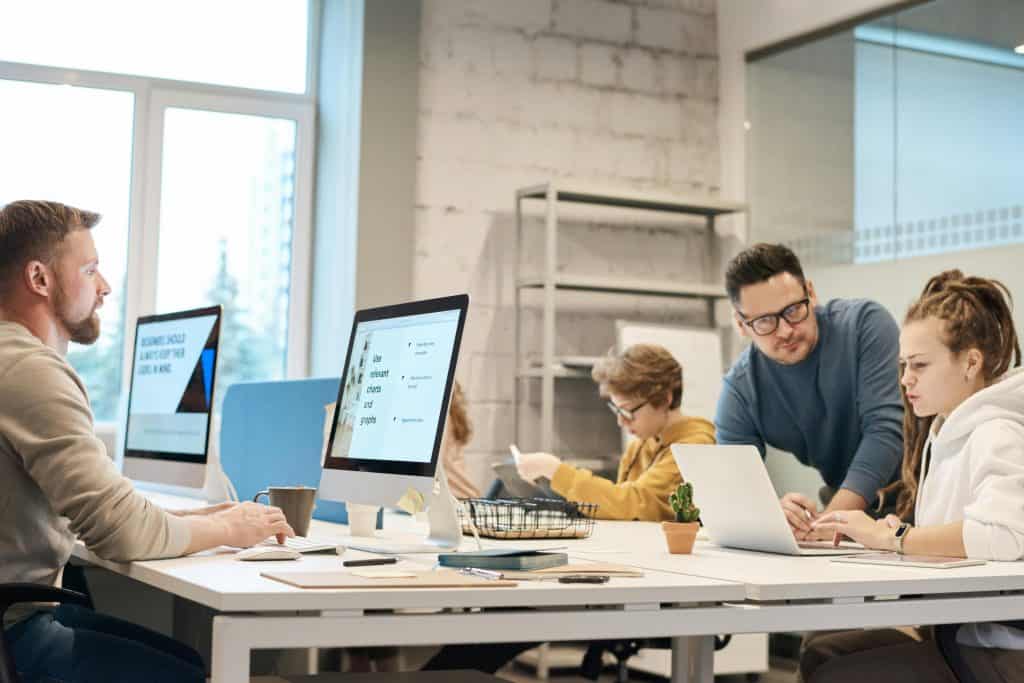 Employees in an office space working in front of their computer