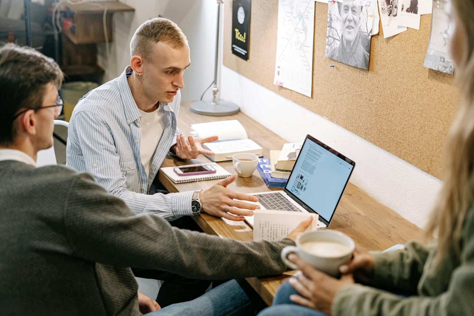 Three employees having a meeting in front of a laptop