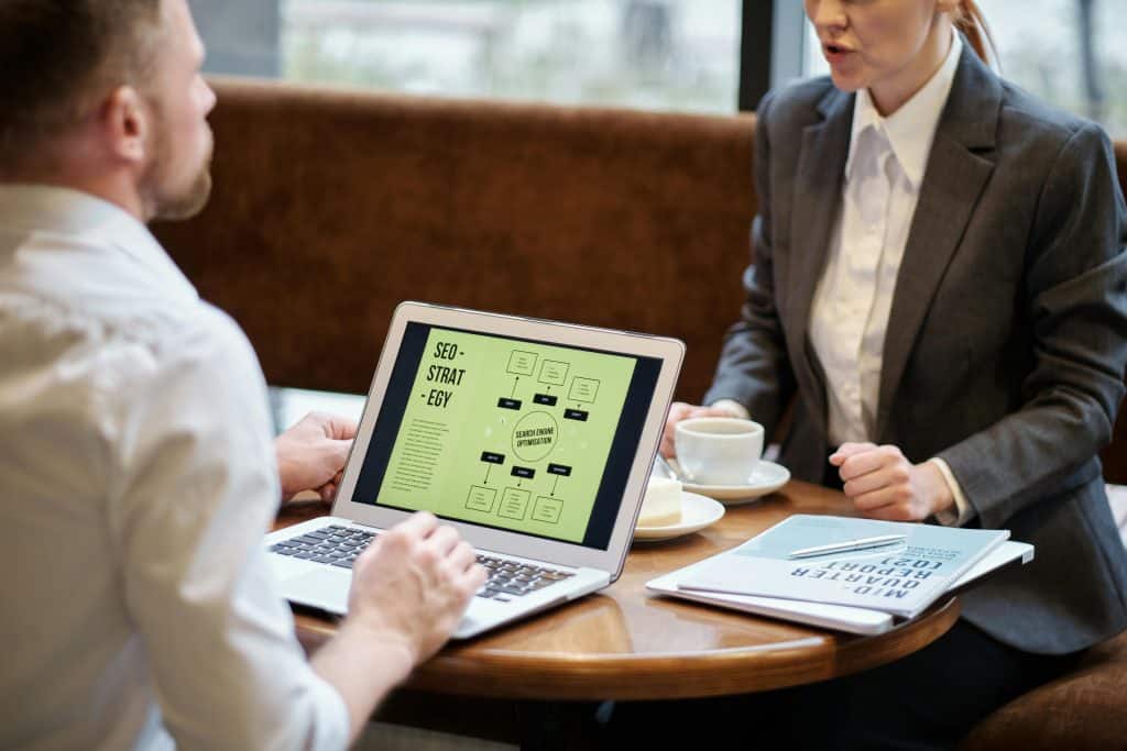 Colleagues having a meeting in a restaurant with a laptop on the table