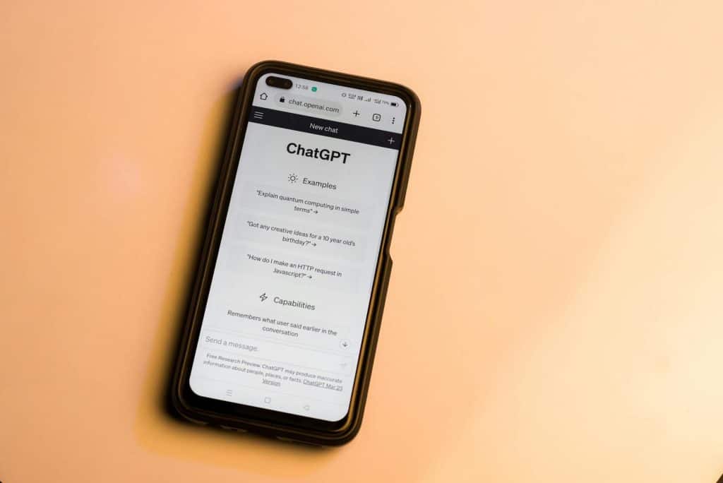 Smartphone on peach background displaying the ChatGPT website